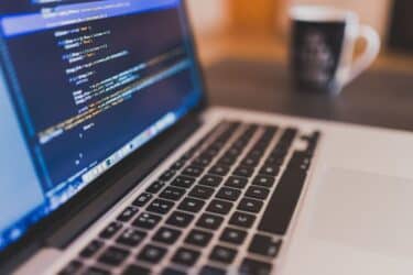 Notebook moderna usada por programador en ambiente laboral