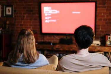 Pareja viendo Smart TV en sala acogedora