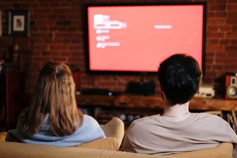 Pareja viendo Smart TV en sala acogedora